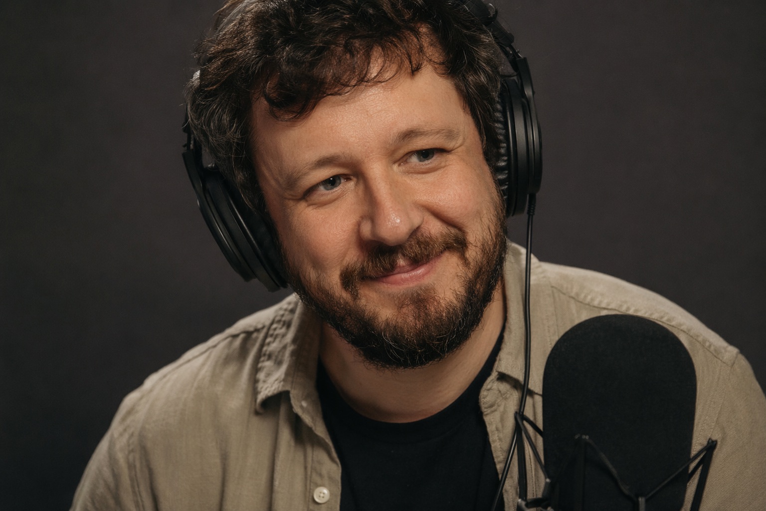 Narrator recording an audiobook on a broadcast mic with the manuscript on the teleprompter